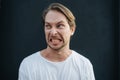 Angry man clenched his teeth in anger at dark wall Royalty Free Stock Photo