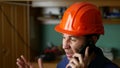 Angry man construction worker in a hardhat shouting, talking on the phone smartphone Royalty Free Stock Photo