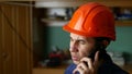 Angry man construction worker in a hardhat shouting, talking on the phone smartphone Royalty Free Stock Photo