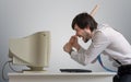 Angry man is destroying old computer with baseball bat in office. Royalty Free Stock Photo