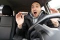 Angry man driving a car. Male driver gesturing and shouting behind the wheel of the car. Royalty Free Stock Photo