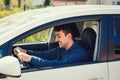 Angry man driving a vehicle. Irritated and furious man holding the steering wheel tight, grinding teeth Royalty Free Stock Photo