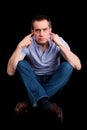 Angry Man Fingers in Ears Not Listening Cross Legged Royalty Free Stock Photo