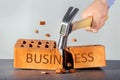 Angry man with hammer breaking brick-symbol business.