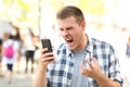 Angry man holding crashed phone Royalty Free Stock Photo