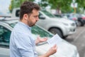 Angry man looking on parking ticket placed under windshield wiper Royalty Free Stock Photo