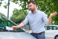 Angry man looking on parking ticket placed under windshield wiper Royalty Free Stock Photo