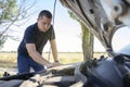 An angry man looks at the idle car engine. The driver tries to explain the cause of the breakdown to the mechanic using his