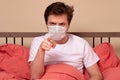 Angry man in medical mask pointing his finger at you sitting in the bed at home Royalty Free Stock Photo