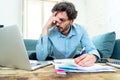 Angry man paying bills as home with laptop and calculator Royalty Free Stock Photo