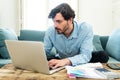 Angry man paying bills as home with laptop and calculator Royalty Free Stock Photo