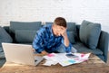 Angry man paying bills managing finances feeling desperate and hopeless with too much debts