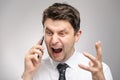 Angry man screaming on client by phone. Aggressive boss calling employee who didn`t finish his work on time. Royalty Free Stock Photo