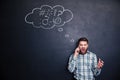 Angry man shouting on cell phone standing over black board Royalty Free Stock Photo