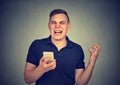 Angry man shouting at his cell phone, enraged with the bad service poor quality of smartphone Royalty Free Stock Photo