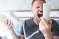 Angry man shouting into phone in hotel room