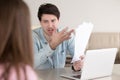 Angry man shouting at woman pointing at documents in hand Royalty Free Stock Photo