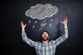 Angry man standing and shouting over blackboard with drawn raincloud Royalty Free Stock Photo