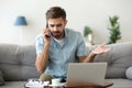 Angry man talking on phone disputing over computer laptop problem Royalty Free Stock Photo