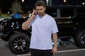 Angry man talking on phone on night urban street. Dangerous aggressive man talking on phone with serious face. Criminal Royalty Free Stock Photo