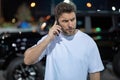 Angry man talking on phone on night urban street. Dangerous aggressive man talking on phone with serious face. Criminal Royalty Free Stock Photo