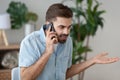 Angry man talking on smartphone solving work problem