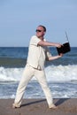 Angry man throwing his laptop at the beach Royalty Free Stock Photo