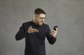 Angry man waves his hand and indignantly shouts at his smartphone after a rough conversation. Royalty Free Stock Photo