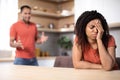 Angry millennial african american husband yelling at upset offended wife in kitchen interior, blurred Royalty Free Stock Photo