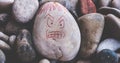 Angry nasty face draw on stones for anger attack in lonely mind nervous neurology horizontal