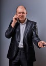 Angry not undestanding gloomy stressed angry business man talking on mobile phone very emotional in office suit on grey background Royalty Free Stock Photo