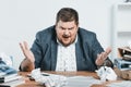 angry overweight businessman in suit working with documents