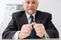 Angry powerful businessman breaking pencil in the office