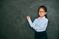 Angry pretty little teacher pointing blackboard