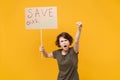 Angry protesting woman hold protest sign broadsheet placard on stick clenching fist screaming isolated on yellow