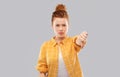 Angry red haired teenage girl showing thumbs down Royalty Free Stock Photo