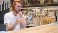 Angry Redhead Man Screaming, Talking on Mobile Phone in Cafe Royalty Free Stock Photo