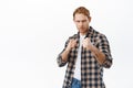 Angry redhead man standing in fighting pose, frowning serious, going to fight or box with someone, determined to punch