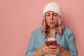 Angry sad caucasian woman holding smartphone having problem with phone on pink background. Mock up copy space Royalty Free Stock Photo