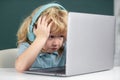 Angry sad school kid working in computer class. Little funny system administrator or programmer. Royalty Free Stock Photo