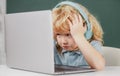 Angry sad school kid working in computer class. Little funny system administrator or programmer. Royalty Free Stock Photo