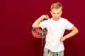 Angry School boy with backpack, on red wall