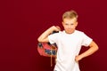 Angry School boy with backpack, on red wall