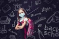 Angry schoolgirl in protective mask is preparing to go to school. Virus protection for children