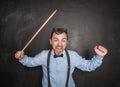 Angry screaming teacher with pointer on blackboard Royalty Free Stock Photo