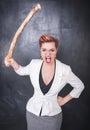 Angry screaming teacher with wooden stick on blackboard background Royalty Free Stock Photo