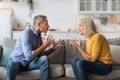 Angry Senior Couple Having Quarrel Shouting Sitting At Home Royalty Free Stock Photo