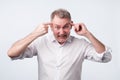 Angry senior man gesturing with his finger against temple asking are you crazy Royalty Free Stock Photo