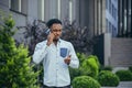 Angry and serious african american businessman talking on the phone quarreling walking near the house Royalty Free Stock Photo