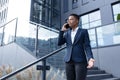 Angry and serious businesswoman talking on the phone outside the office, African American woman dressed in business clothes, Royalty Free Stock Photo